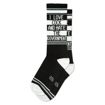 A black crew sock with white text "I LOVE COCK AND HATE THE GOVERNMENT" on a white stripe, black and white stripes. White heel/toe.