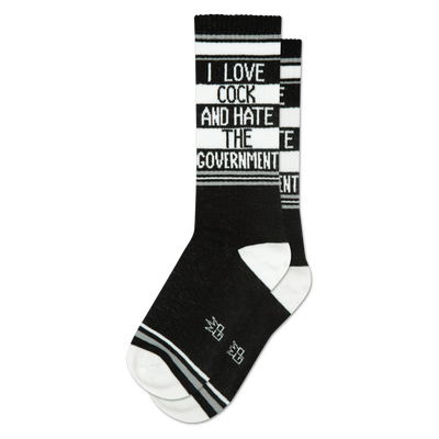 A black crew sock with white text "I LOVE COCK AND HATE THE GOVERNMENT" on a white stripe, black and white stripes. White heel/toe.