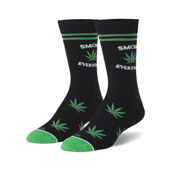 Pair of black crew socks with green stripes, toes, and green cannabis leaf patterns, text reads 'SMOKE EVERYDAY'.