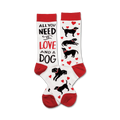 A pair of crew socks with a red and white design.  The socks feature black labrador silhouettes, red hearts, and the text 'All You Need Is Love And A Dog'.