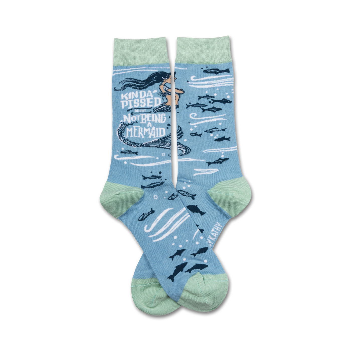 A pair of crew socks in light blue and mint green. The design features a cartoon mermaid with the text 'Kinda Pissed About Not Being a Mermaid' and small fish.