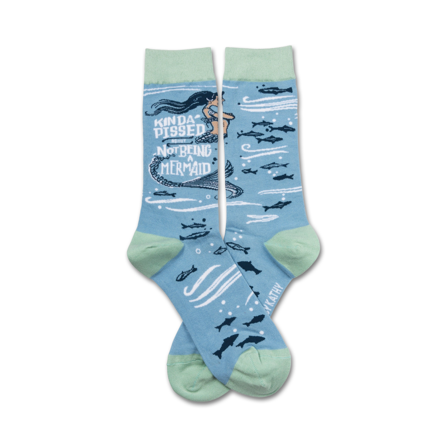A pair of crew socks in light blue and mint green. The design features a cartoon mermaid with the text 'Kinda Pissed About Not Being a Mermaid' and small fish.
