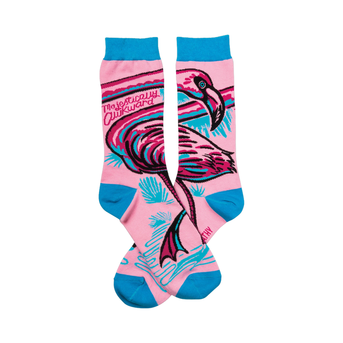 Pair of pink crew socks with a teal and black flamingo design. The words 'Majestically Awkward' are written on the socks. }}