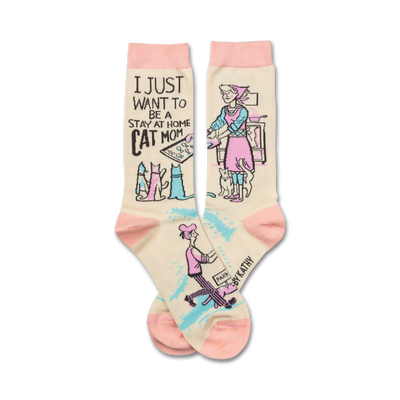 white crew socks with black text "i just want to be a stay at home cat mom" and a drawing of a woman in a pink apron cooking in a kitchen with 4 cats  