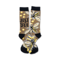 A pair of crew socks with a brown background, yellow and black bees, honeycombs, and the text 'Just Bee'.
