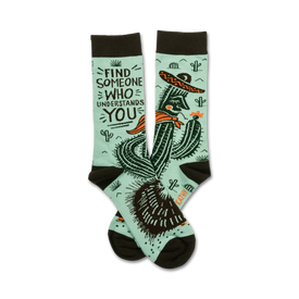 mint green socks with brown toes and heels feature a relaxed cactus in a sombrero smokin' a cigarette surrounded by prickly pears. words state "find someone who understands you."   