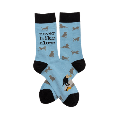 Crew socks in light blue with a repeating pattern of gray dog silhouettes. The text 'Never Hike Alone' is visible on one sock.