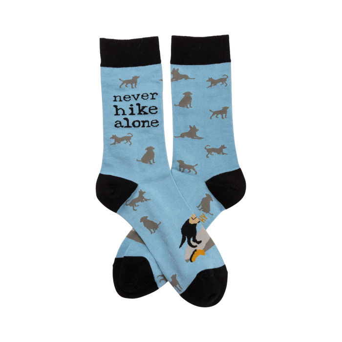 Crew socks in light blue with a repeating pattern of gray dog silhouettes. The text 'Never Hike Alone' is visible on one sock. }}