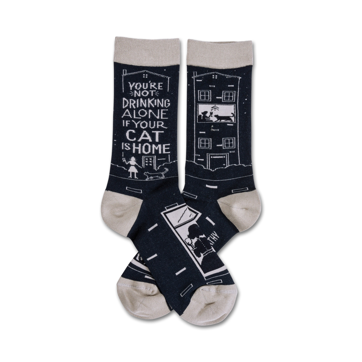 Pair of navy blue crew socks with a light beige cuff. One sock shows a building with a cat in the window, the other says, 'You're not drinking alone if your cat is home'.