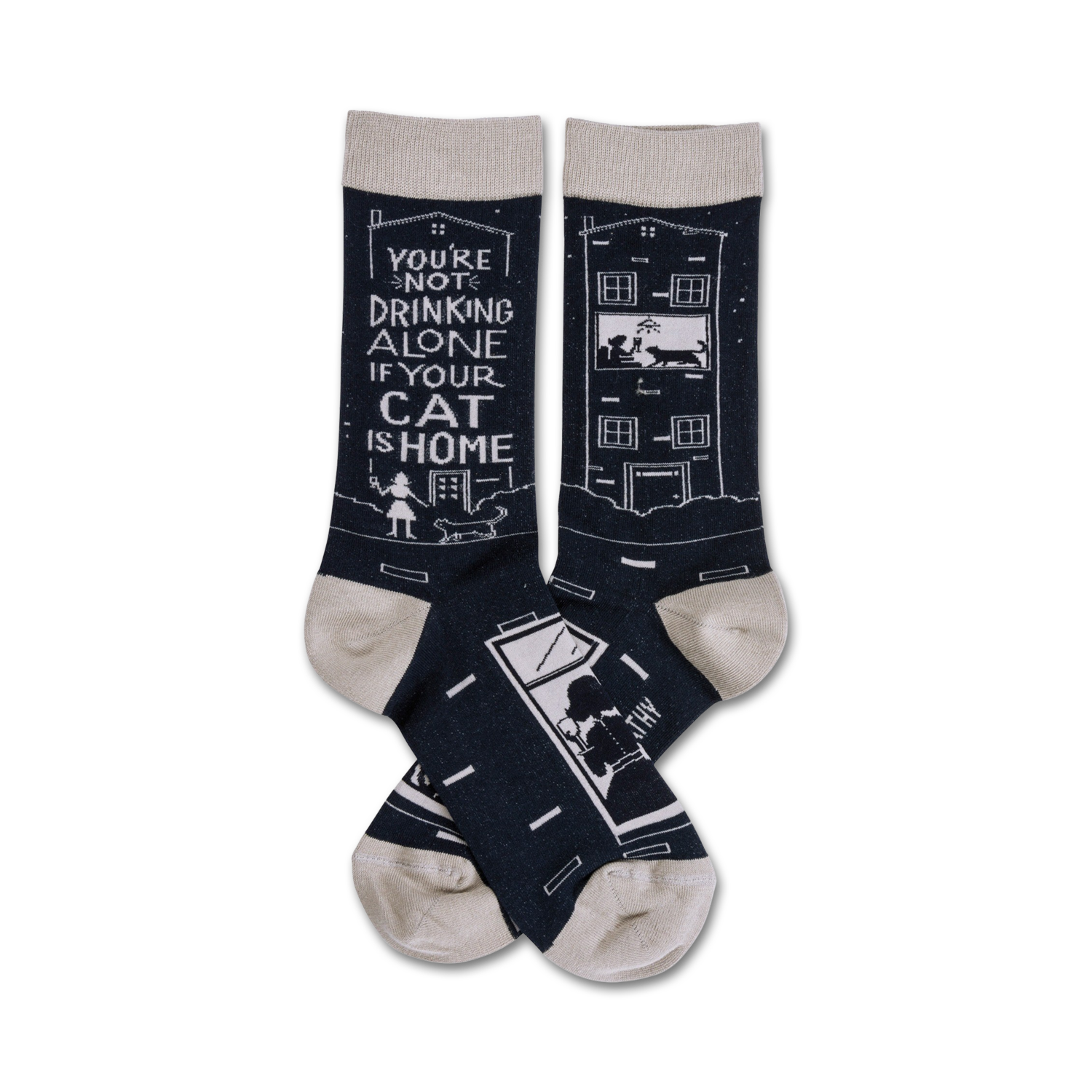 Pair of navy blue crew socks with a light beige cuff. One sock shows a building with a cat in the window, the other says, 'You're not drinking alone if your cat is home'.