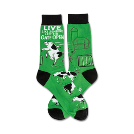 green crew socks with black toes and heels featuring a pattern of cows jumping over a fence. "live like someone left the gate open" text at sock tops.  
