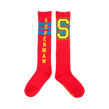 Pair of red knee-high socks. One sock displays 'SUPERMAN' vertically, the other a large yellow 'S' with blue trim. Both have thin blue stripes.