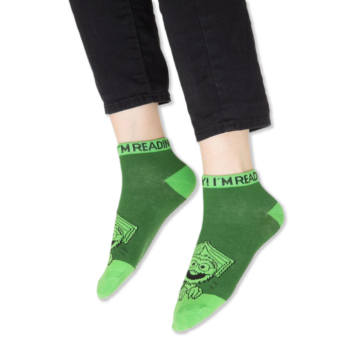 Focus on the blue contrasting cuff of the Cookie Monster sock with partial text visible.