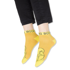 Flat lay of the four vibrant Sesame Street ankle socks displayed against a black background.