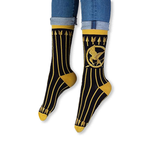 Lifestyle shot of someone wearing the black and gold Mockingjay socks with dark jeans and casual sneakers.