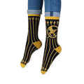 Lifestyle shot of someone wearing the black and gold Mockingjay socks with dark jeans and casual sneakers.