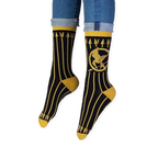 Lifestyle shot of someone wearing the black and gold Mockingjay socks with dark jeans and casual sneakers.