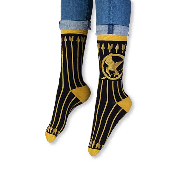 Lifestyle shot of someone wearing the black and gold Mockingjay socks with dark jeans and casual sneakers.
