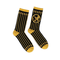 Black crew socks featuring vertical gold arrows, a gold Mockingjay symbol, and contrasting gold cuffs and toe blocks.