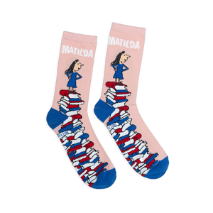 Pink crew socks with blue heels and toes, featuring Matilda standing on a giant tower of colorful books.