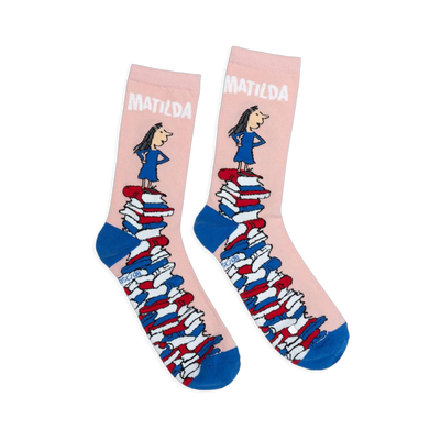 Pink crew socks with blue heels and toes, featuring Matilda standing on a giant tower of colorful books.