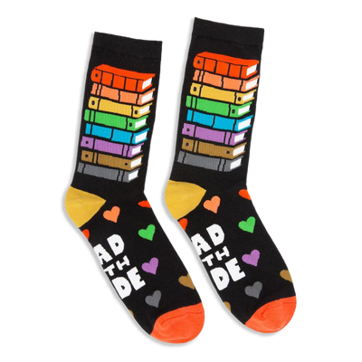 Black crew socks featuring a tall stack of rainbow-colored books on the leg and Read With Pride text with colorful hearts.