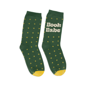 Pair of women's crew socks in forest green with small yellow flower pattern and 'Book Babe' text on one sock. Yellow heel and toe.