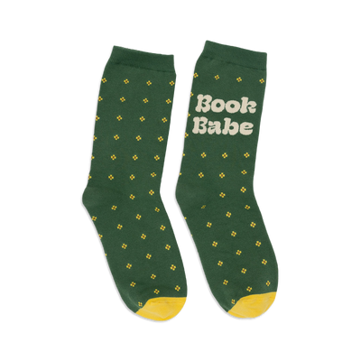 Pair of women's crew socks in forest green with small yellow flower pattern and 'Book Babe' text on one sock. Yellow heel and toe.