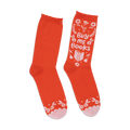 A pair of orange crew socks with a whimsical 'Buy Me Books' design in white and pink.  Features floral accents and a book graphic.