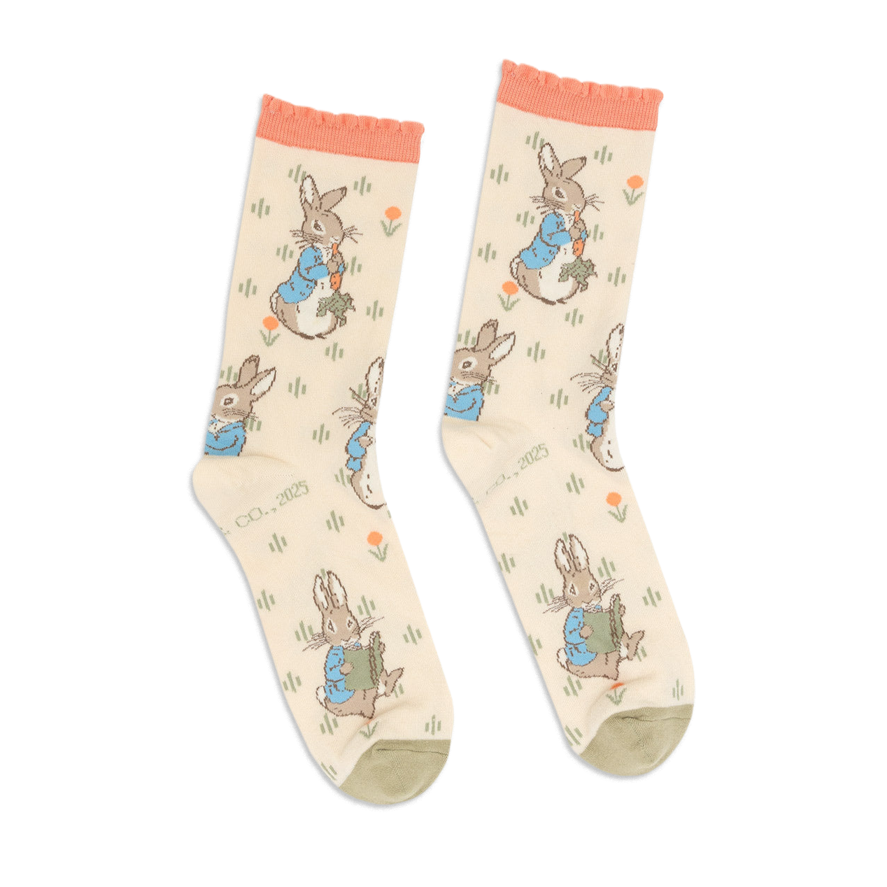 Pair of Peter Rabbit crew socks in light beige, with peach ruffled cuffs and olive green toes, standing upright.