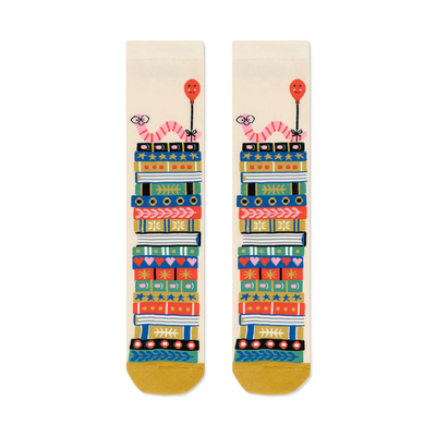 Cream crew socks with a whimsical design of colorful book stacks and pink worms holding balloons.