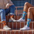 Models on brick steps in puppy print crew socks: orange with beige sneakers, blue with white Converse. [lf]