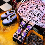 Pair of sheer crew socks featuring a pattern of black cats, twisted purple trees, moons, and stars with solid black cuffs.