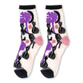 Pair of sheer crew socks featuring a pattern of black cats, twisted purple trees, moons, and stars with solid black cuffs.