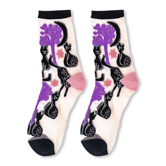 Pair of sheer crew socks featuring a pattern of black cats, twisted purple trees, moons, and stars with solid black cuffs.
