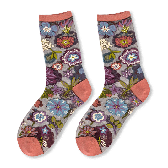Pair of sheer mesh socks on a black background featuring colorful floral embroidery and solid dusty rose cuffs and toes