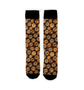 A pair of socks with a pattern of bagels on a black background.