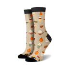 Pair of cream crew socks with a repeating pattern of pumpkins, coffee cups, and cinnamon sticks. Black cuffs.