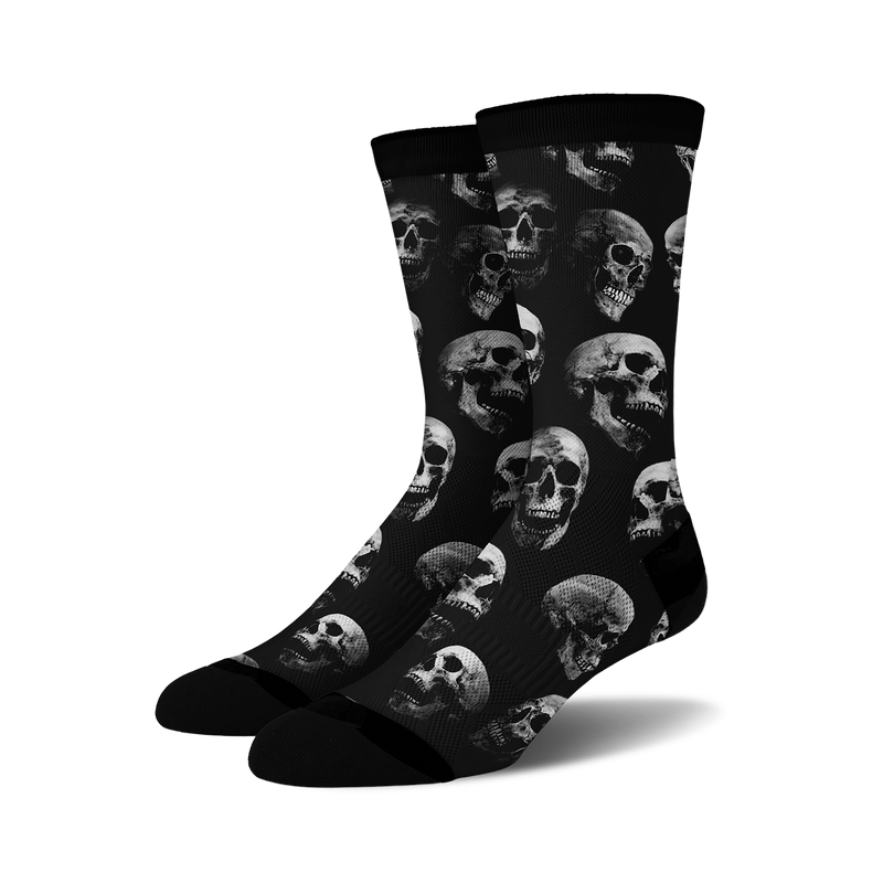 Pair of black crew socks with a repeating grayscale skull pattern.  Edgy and stylish.