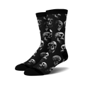 Pair of black crew socks with a repeating grayscale skull pattern. 