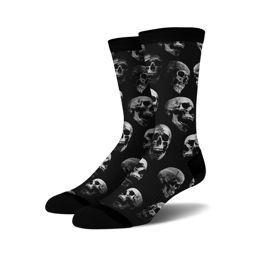 Pair of black crew socks with a repeating grayscale skull pattern. 