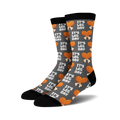 Pair of crew socks, dark grey with orange and white 'It's Leg Day' text and chicken leg illustrations repeating across the fabric.