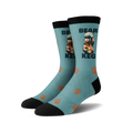A pair of crew socks; teal blue with a brown bear lifting a keg of beer, orange paw prints, and black cuffs.