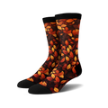 Pair of crew socks with an autumn leaves print.  The socks are predominantly dark brown with orange and red leaves.
