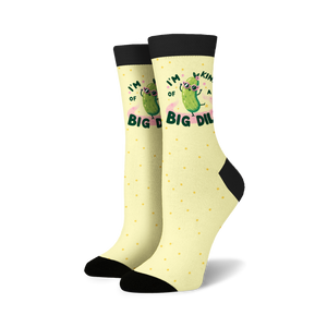 A pair of yellow socks with black toes, heels, and cuffs. The socks have a pattern of black polka dots and a cartoon illustration of a pickle wearing sunglasses and a pink bow. The pickle is surrounded by text that reads 