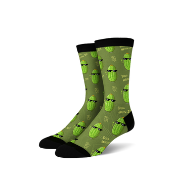 Pair of crew socks in olive green with repeating pattern of cartoon pickles wearing sunglasses and making a hand gesture. 