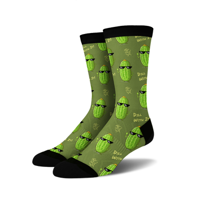 Pair of crew socks in olive green with repeating pattern of cartoon pickles wearing sunglasses and making a hand gesture.