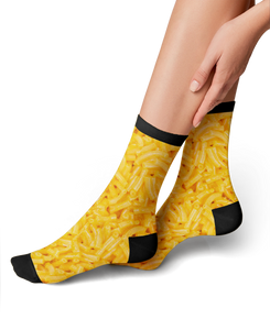 A pair of socks with a pattern of macaroni and cheese on a white background. The socks have black toes and heels.