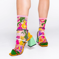 Person wearing sheer colorful cat socks with strappy block heels featuring green, yellow, and pink elements.
