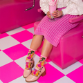 Close up of sheer sock material highlighting quirky, brightly colored cat faces in green, purple, yellow, and pink.